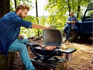 Deux hommes qui préparent un barbecue dans les bois